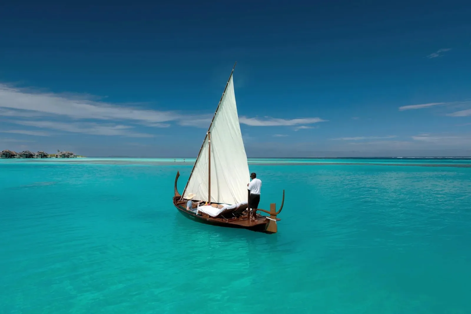 A sailing dhoni on the lagoon, a sailor at the bow