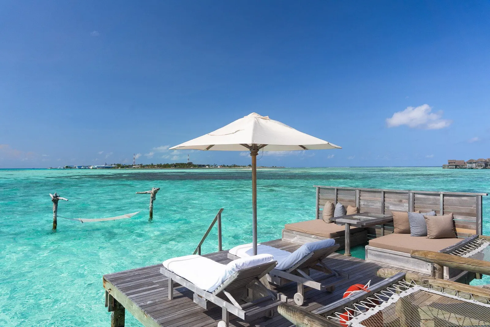 An Island View Crusoe Residence’s deck, umbrella and loungers over the water