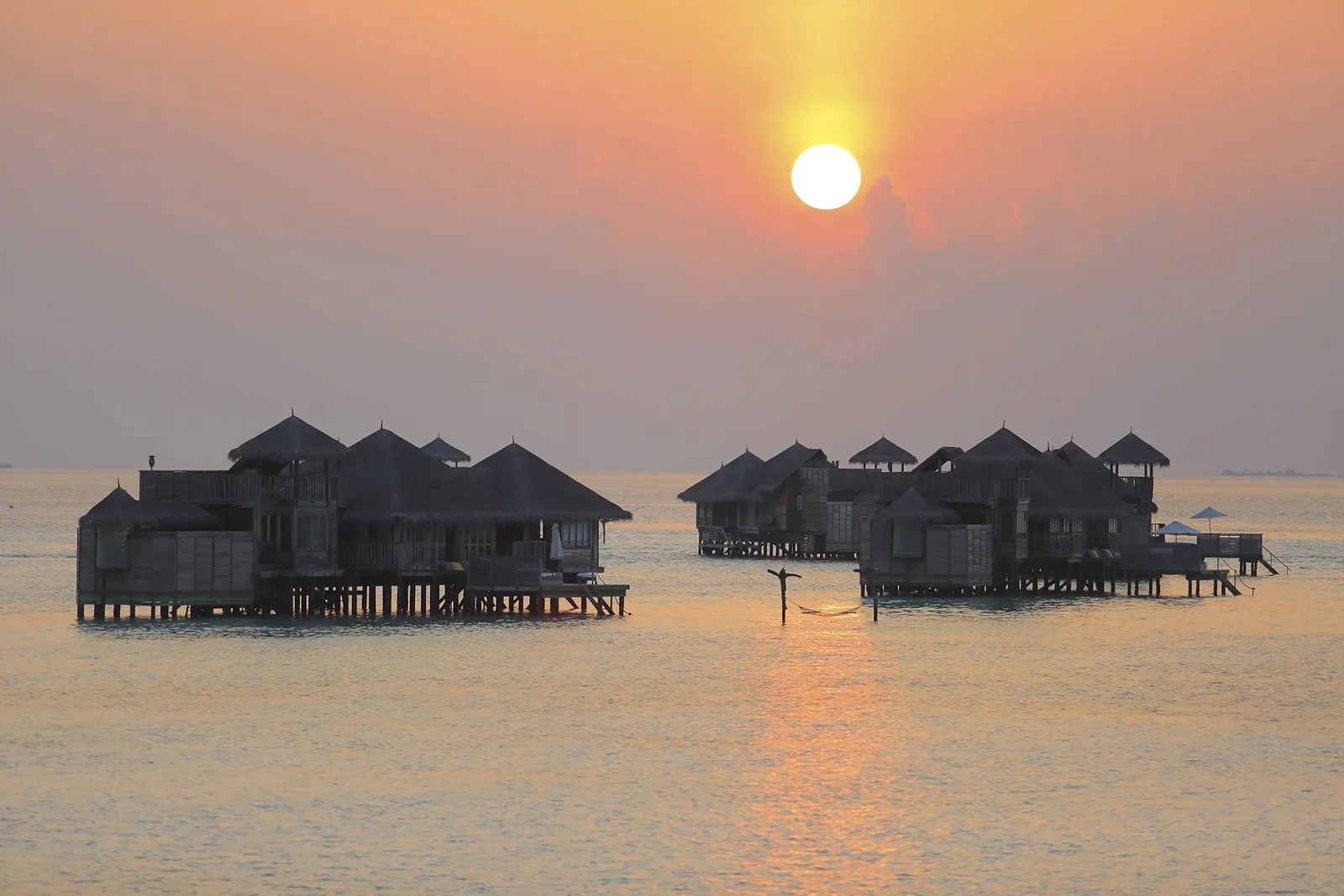 The Crusoe Residences in the lagoon, against the sunset