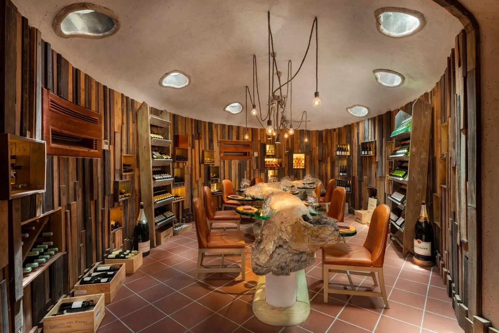The underground wine cellar, its wooden table in the middle and bottles on the walls