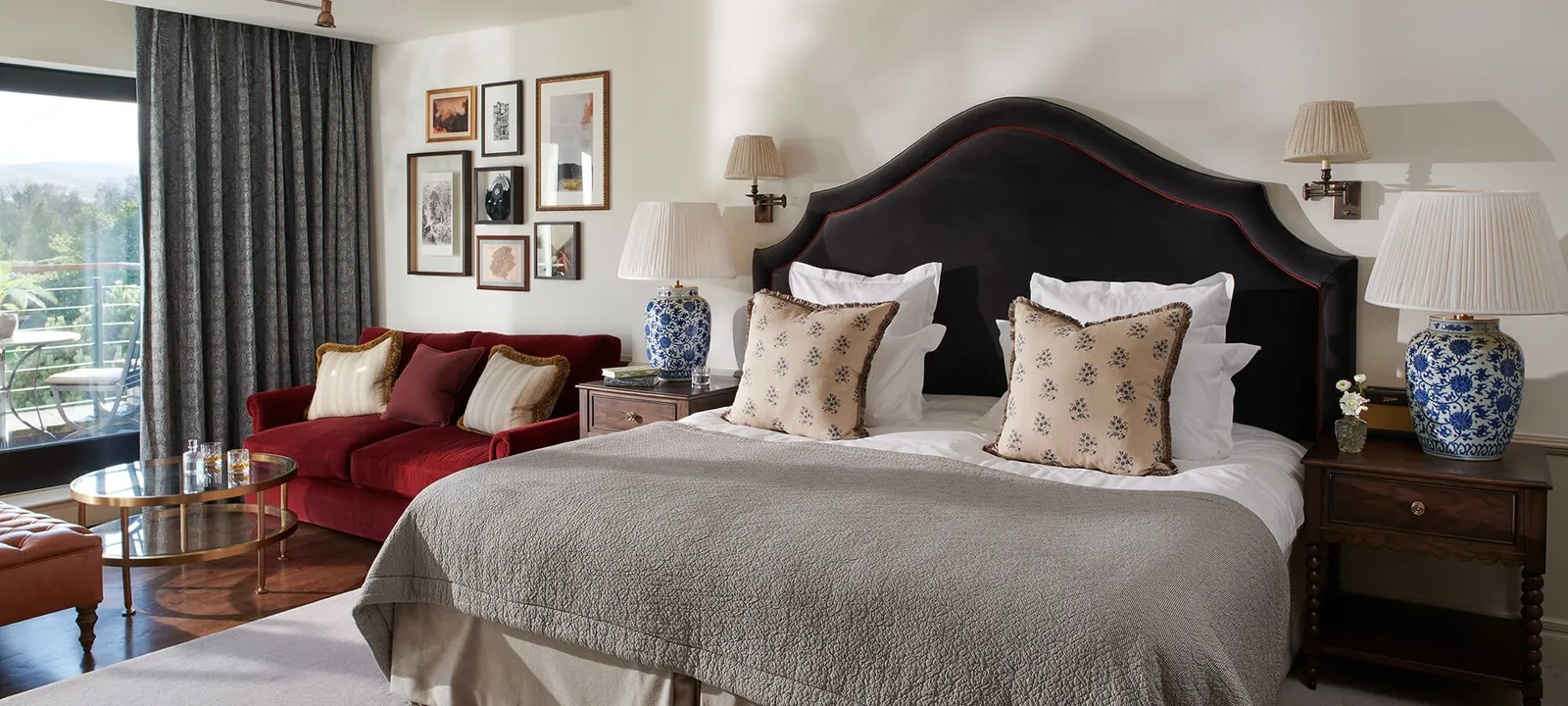 An Estate Room in Braid House with a red sofa beside the bed