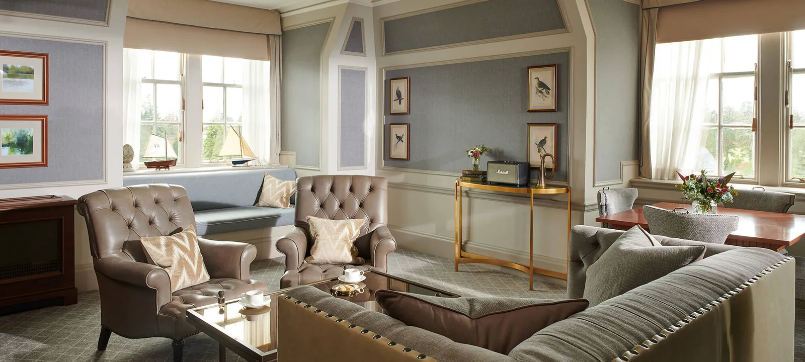 An Estate Suite’s sitting room with sofas and leather armchairs