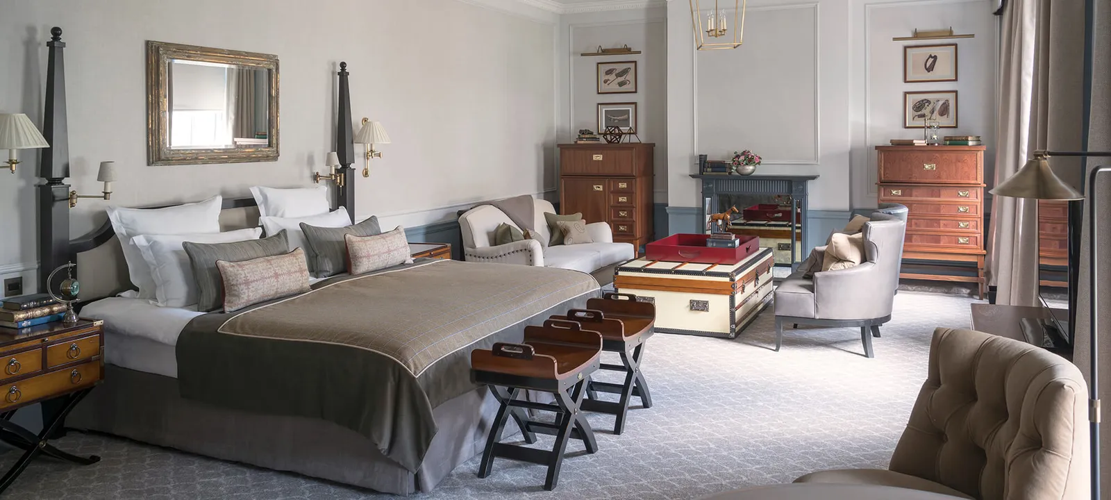 A Manor Room with a trunk at the foot of the bed and a fireplace