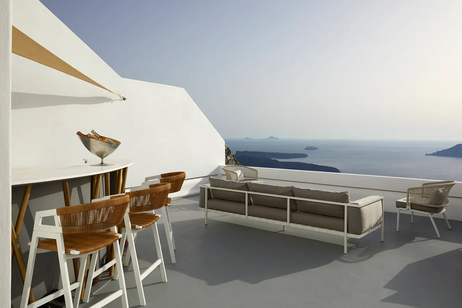 The 363 Bar’s counter with its wood and rope stools, a silver ice bucket and sofas on the terrace open to the sea.