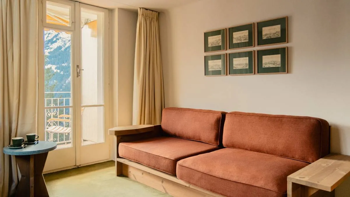 The rust-coloured sofa has a pale timber frame.
