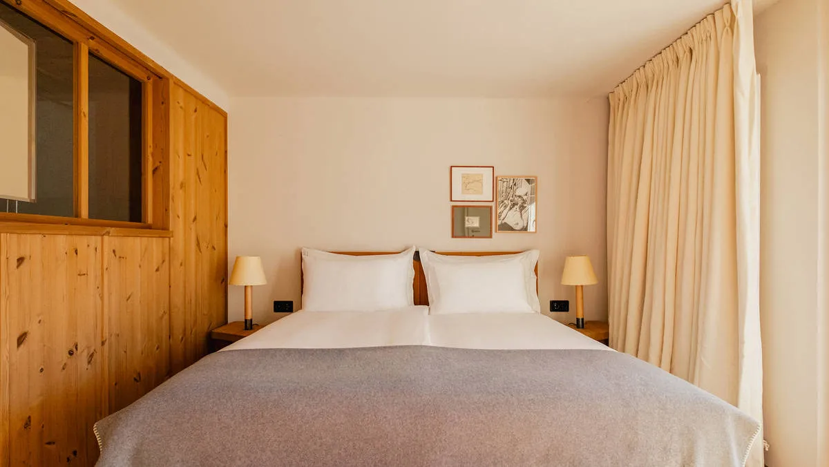 An internal window breaks up the timber wall beside the bed.