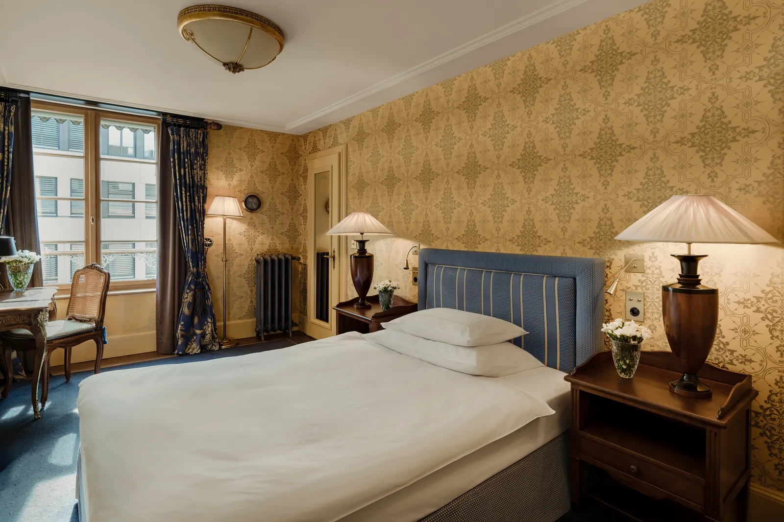 The City Business Room bed between gold-papered walls