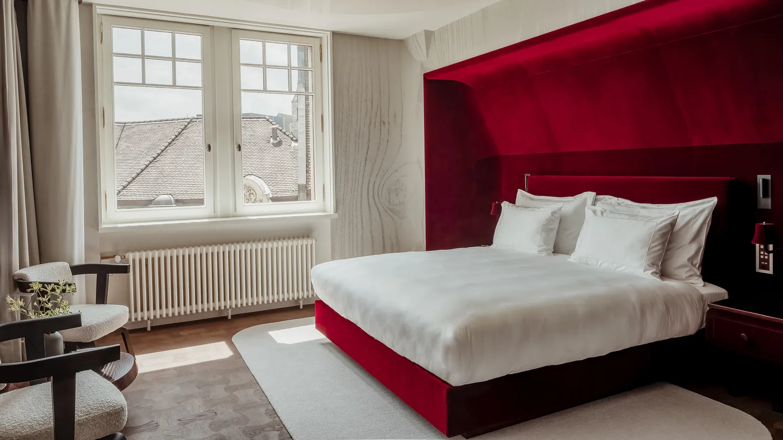 The red alcove and bed of the City King Room Blumenrain 2