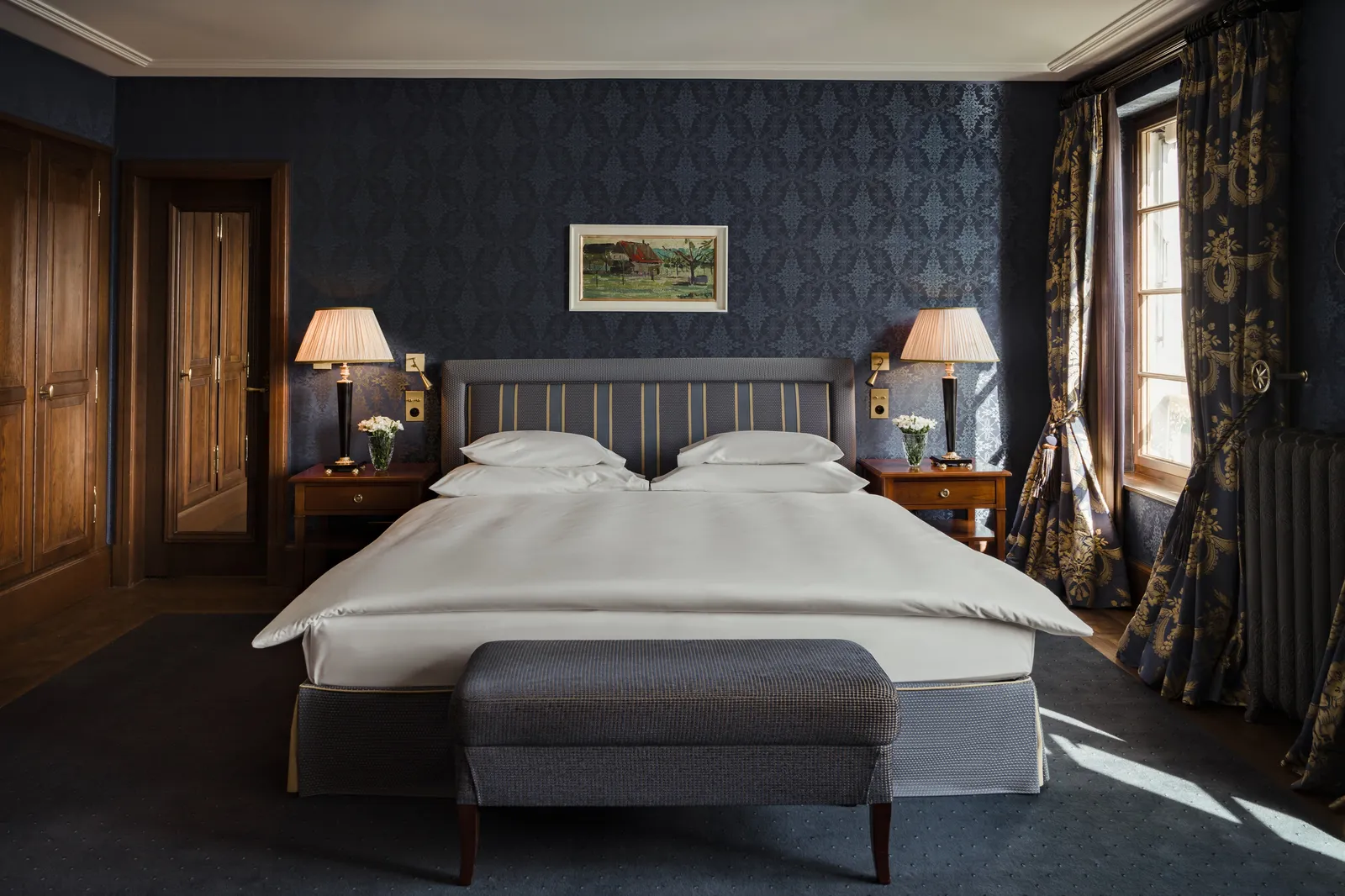 The River Junior Suite bed between blue walls