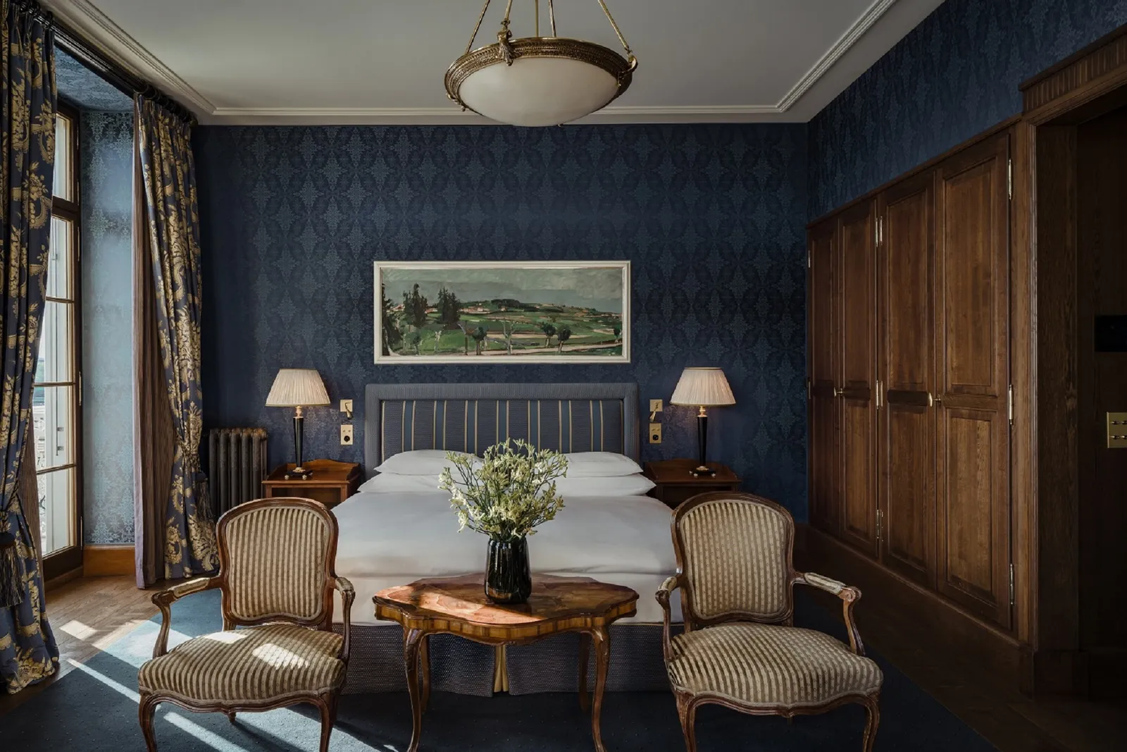 The armchairs and bed of the River Junior Suite Balcony