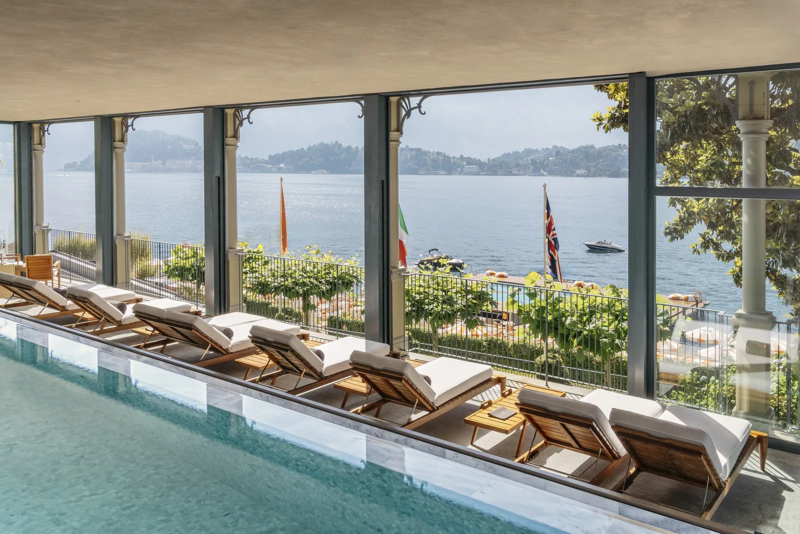 L’infinity pool della T Spa con le vetrate aperte sul lago e i lettini