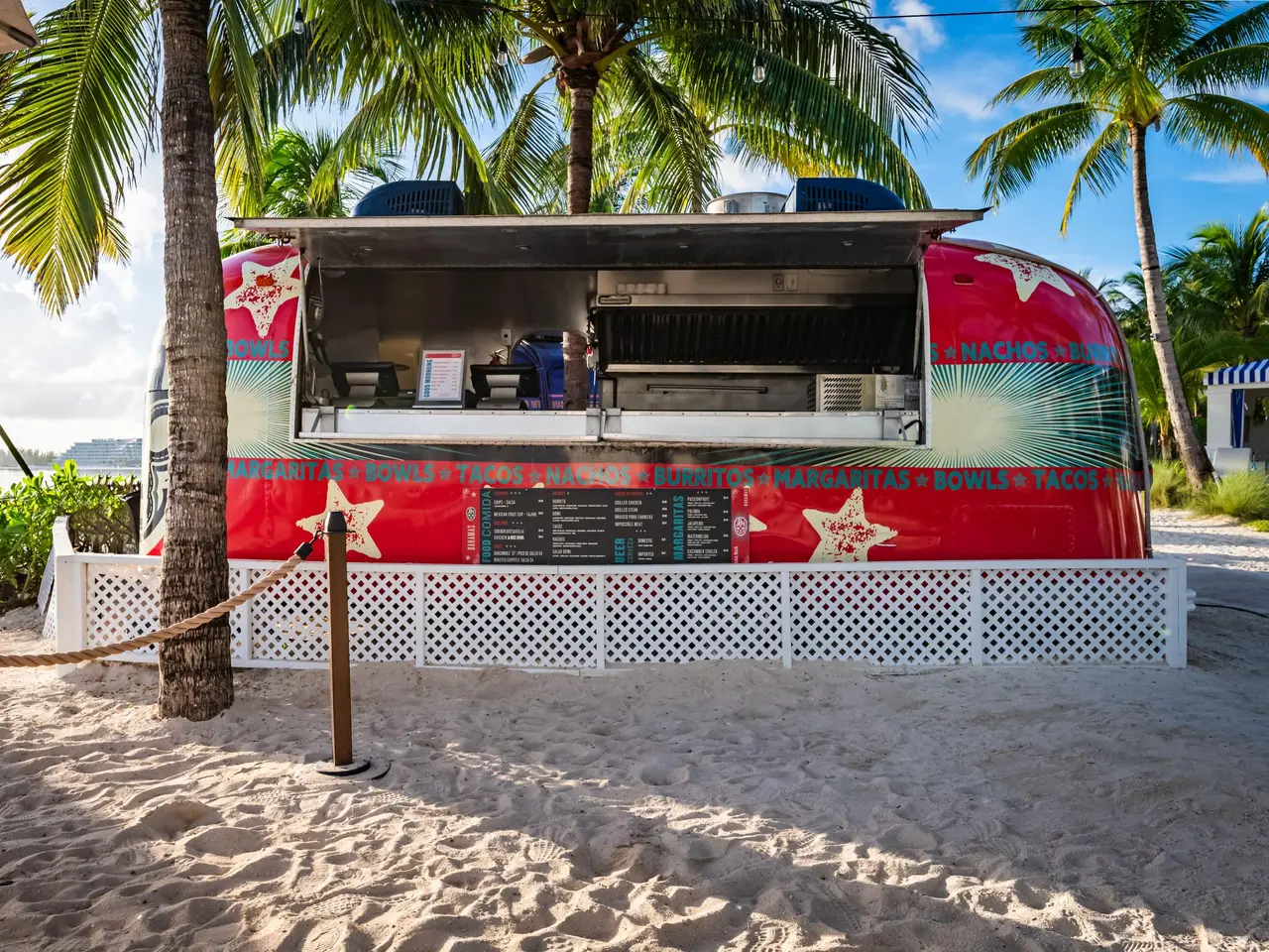 The El Jefe truck on the sand: an Airstream trailer painted red with stars, its counter open, among the palms.