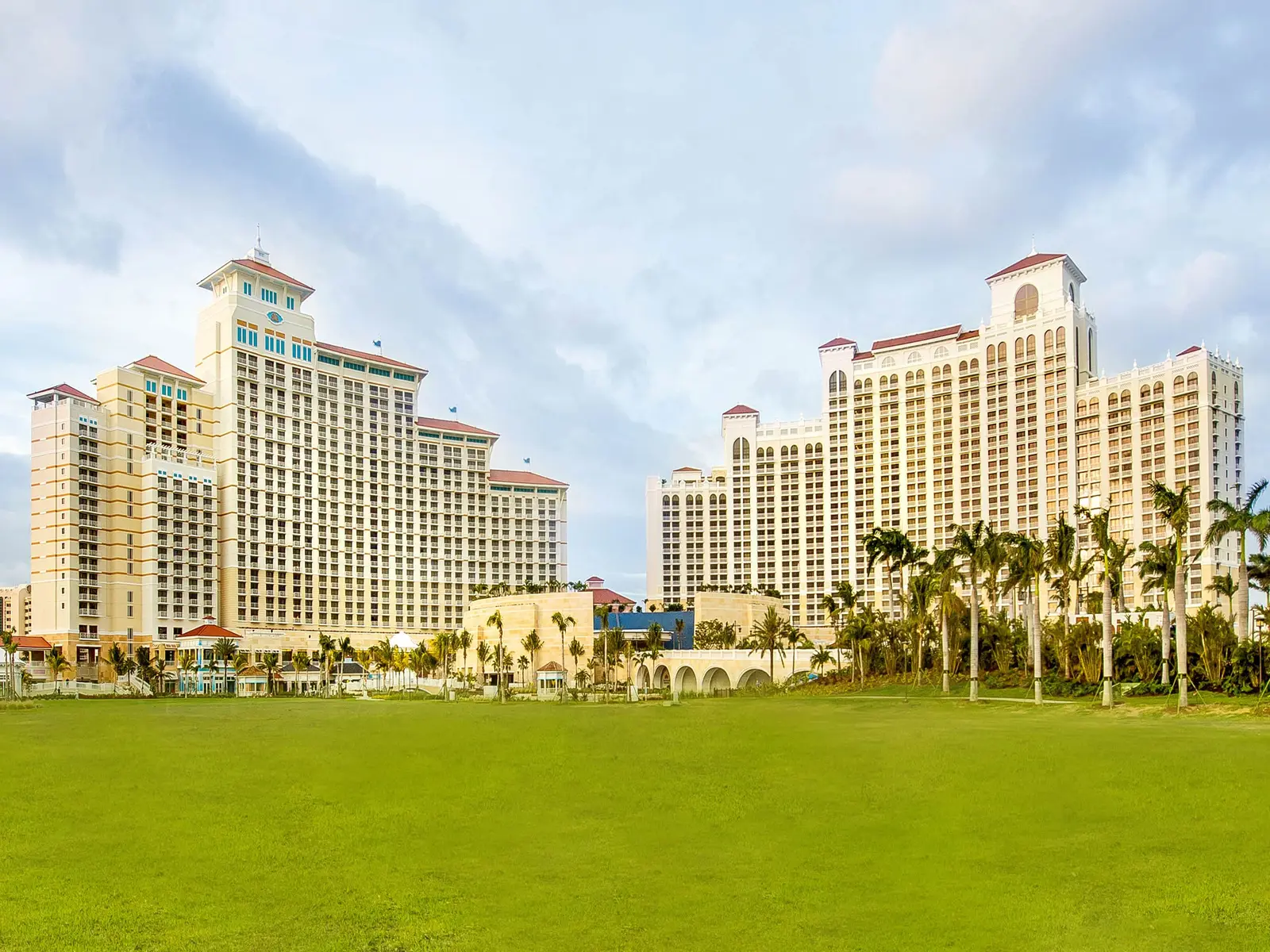 The Grand Hyatt’s 2 sand-coloured towers with their pavilion roofs, behind a wide lawn and a line of palms.