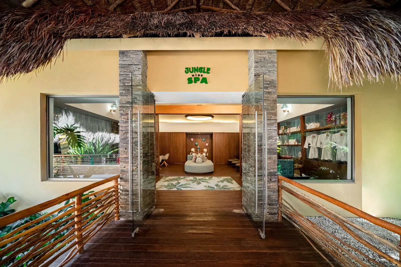 Ingresso della Jungle Kids’ Spa con tetto di palapa e corrimano in legno