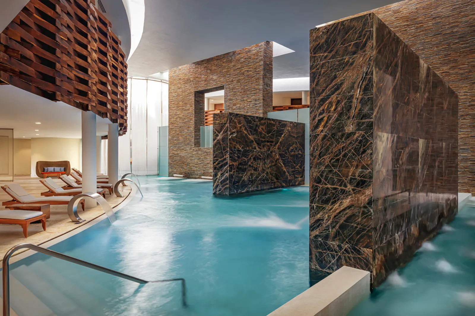 Clear-water pool and waterfalls between the stone walls of SE Spa