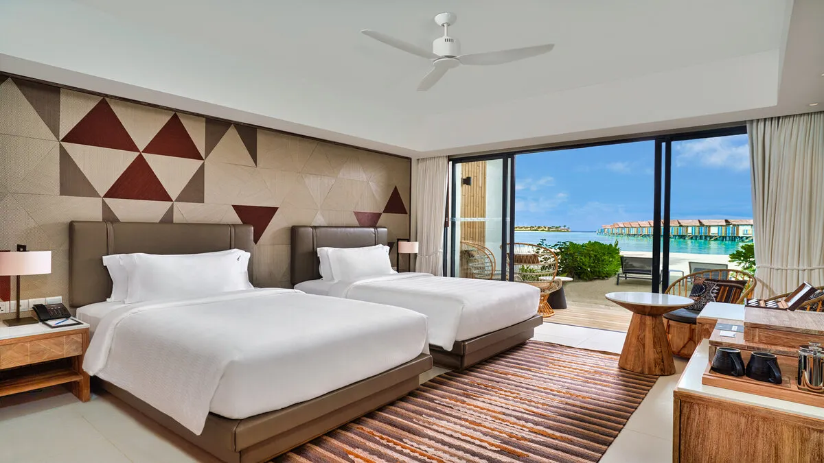 A Silver Beach Studio with 2 beds, the terrace and the beach beyond the glass