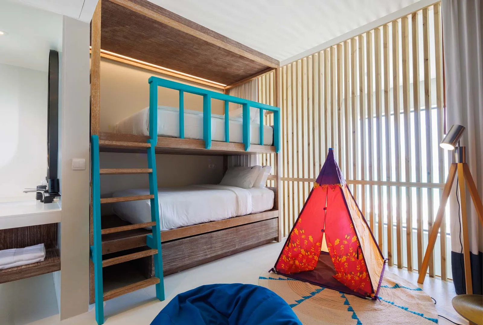 The children’s room of a Silver Family Suite: a turquoise bunk bed and a red teepee