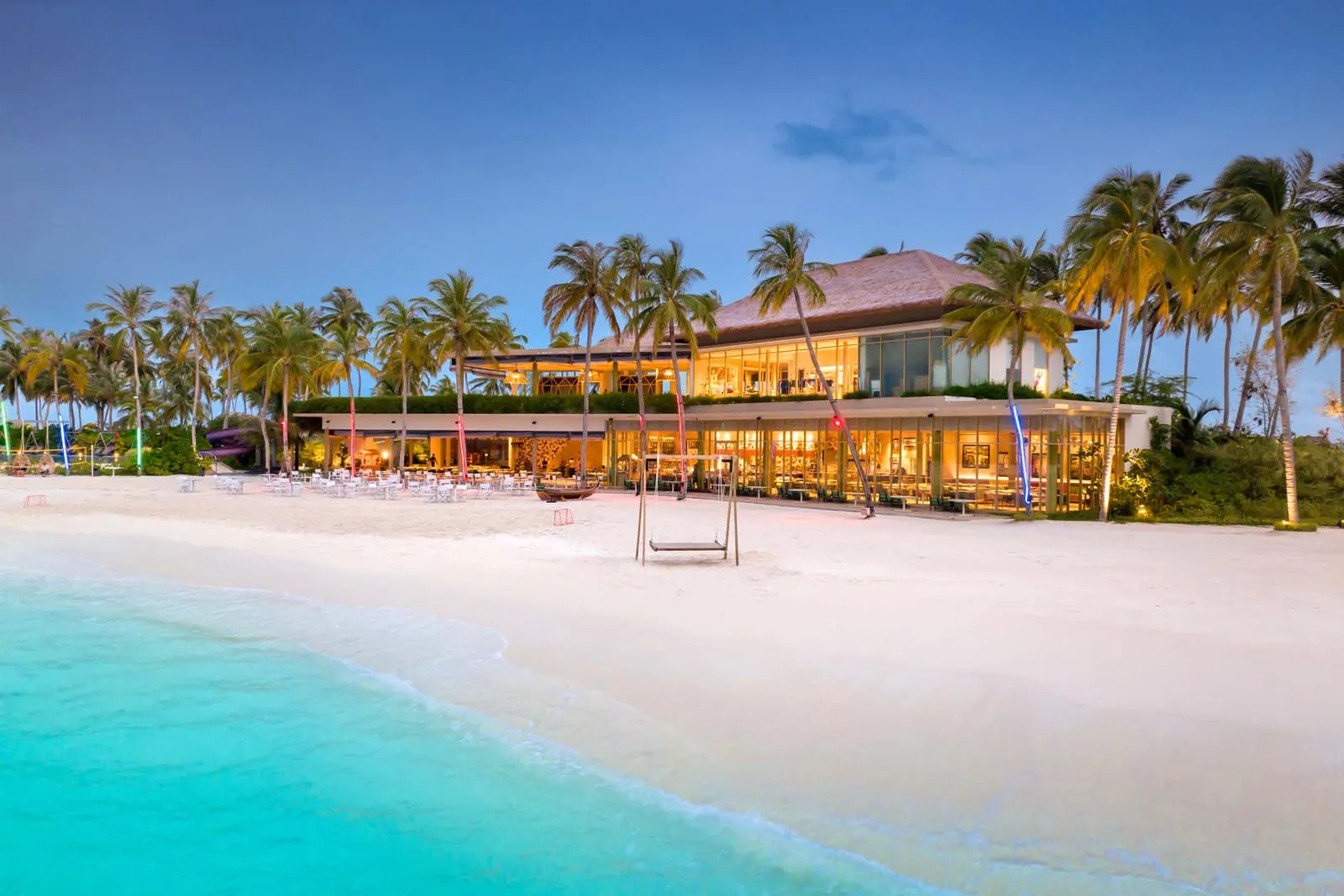 Sessions at dusk, its lights on along the beach and a swing on the sand