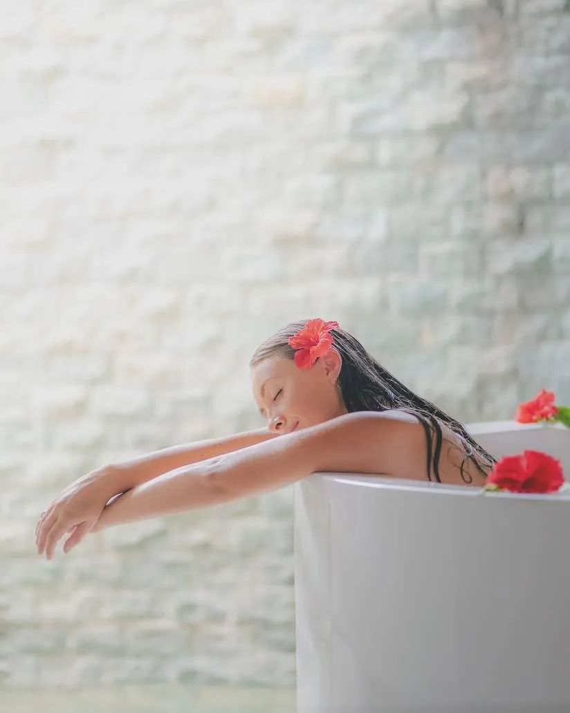 A woman in a bath with flowers, in the spa’s official photograph.