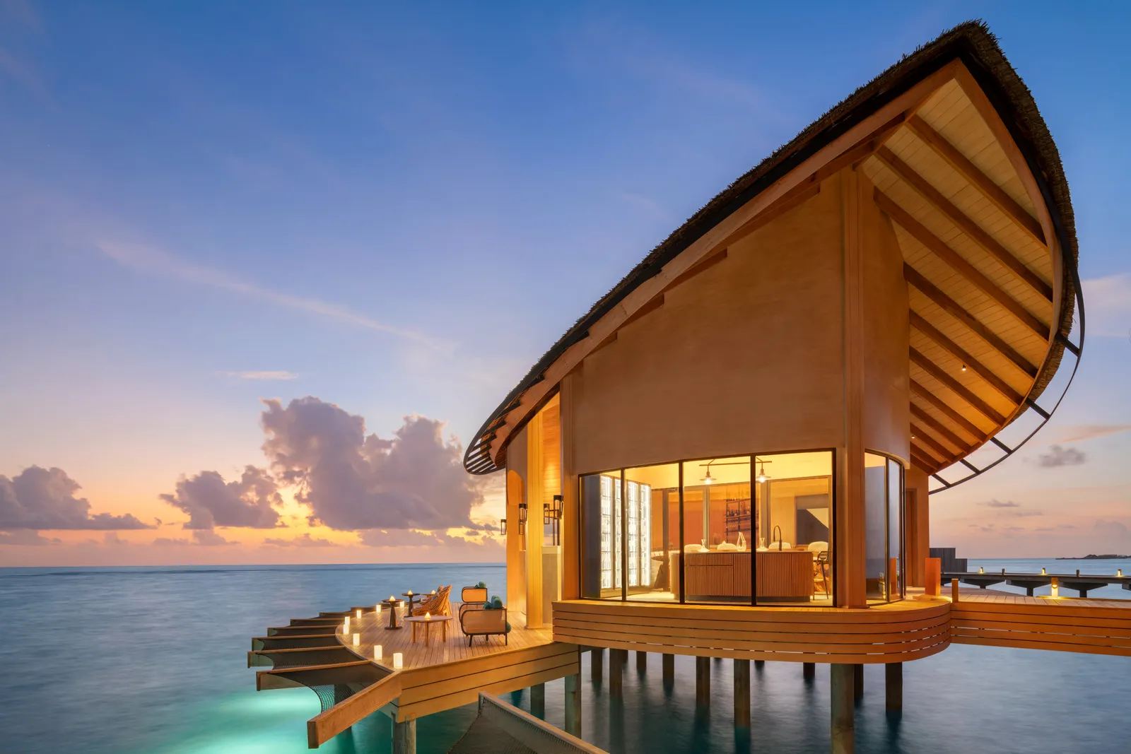 Eden, the overwater champagne and gin bar, lit up at sunset.