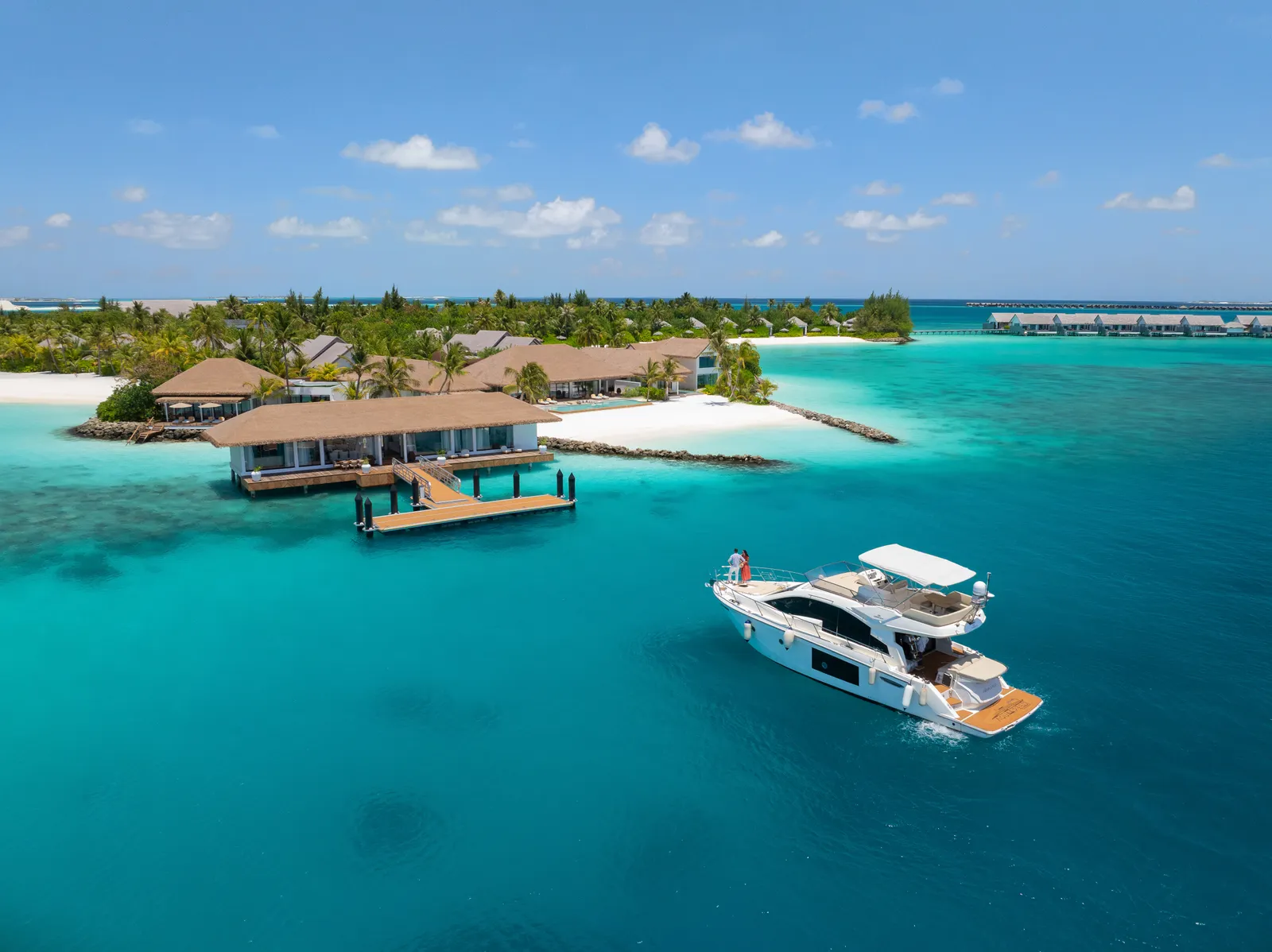 A yacht arriving at The Residence’s private jetty in its cove, with the island’s villas behind.