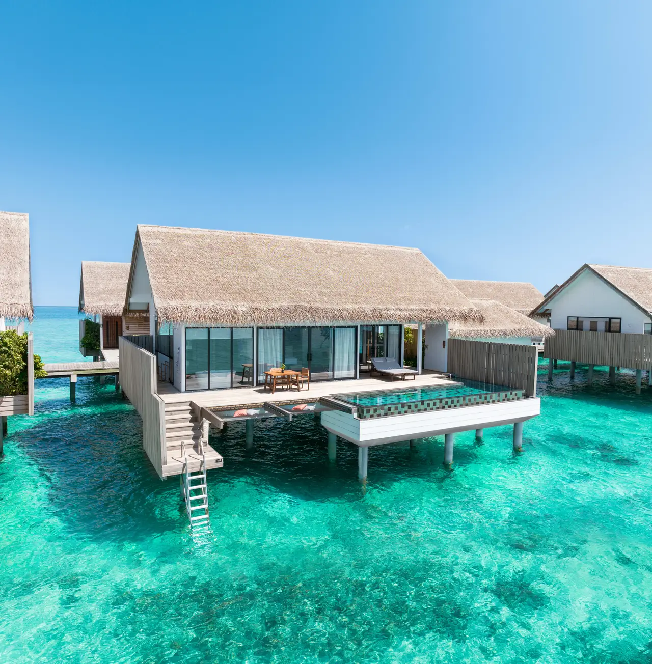 A One Bedroom Overwater Suite with Pool from above, its deck pool and the steps down to the lagoon.