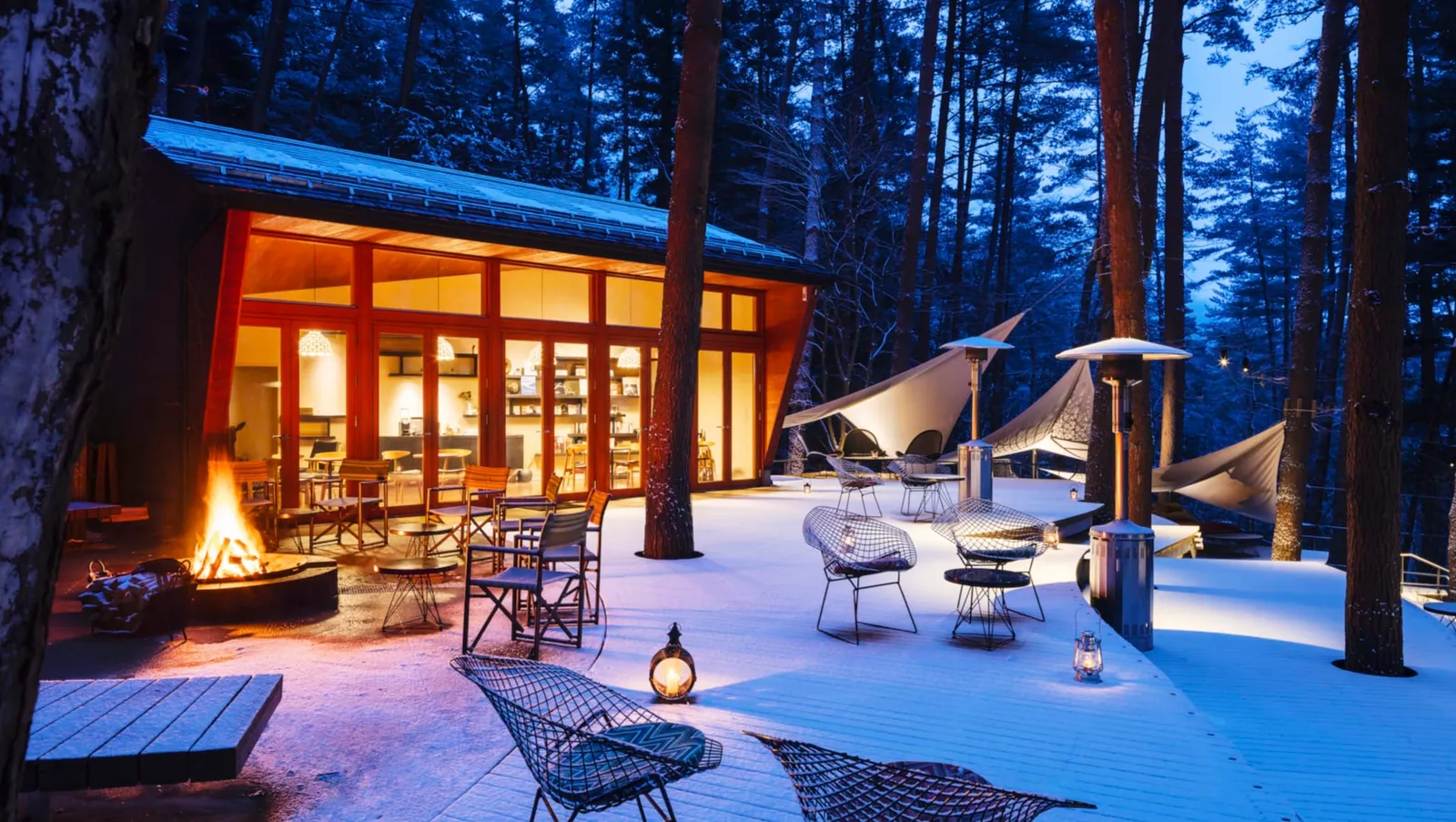 The Cloud Terrace under snow at dusk, the Library Cafe lit and a fire burning