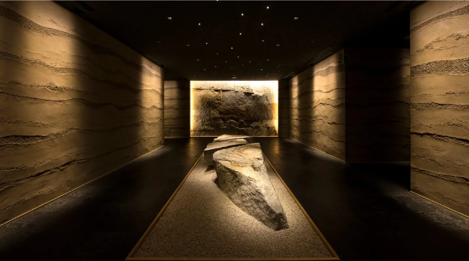 The corridor of rammed earth and stone that leads to the restaurant in the basement.