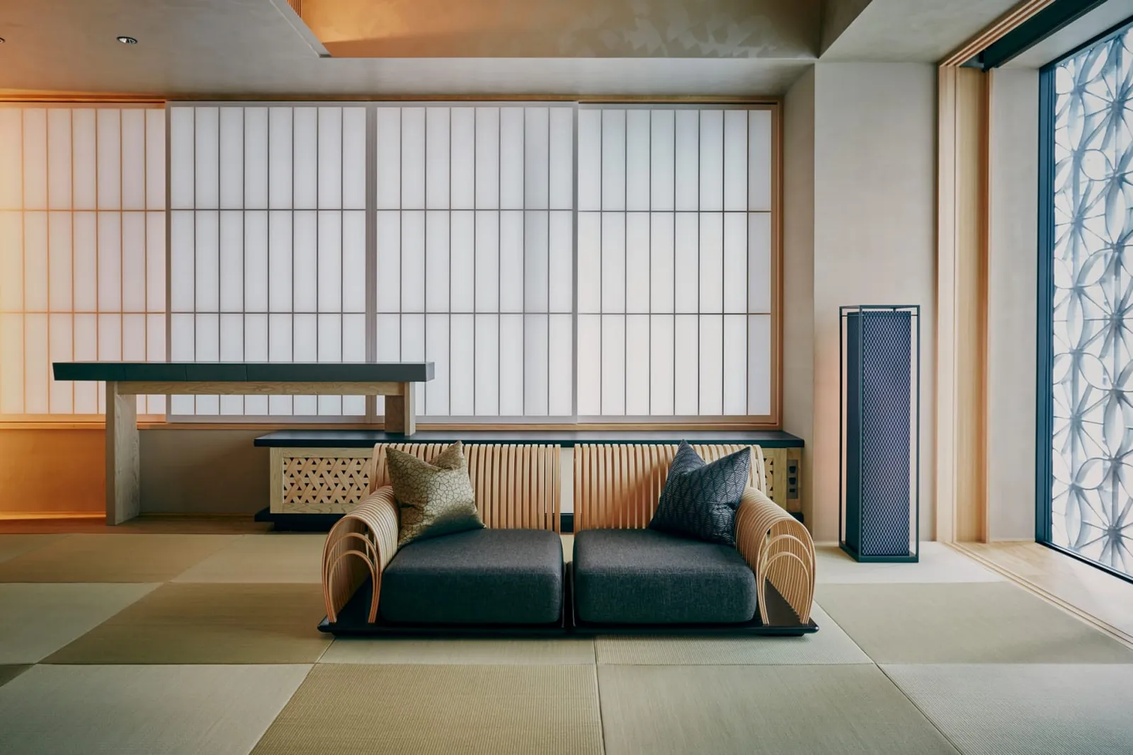 A Sakura room: the low bamboo sofa on the tatami, the grey wall and rice-paper screens at the window.