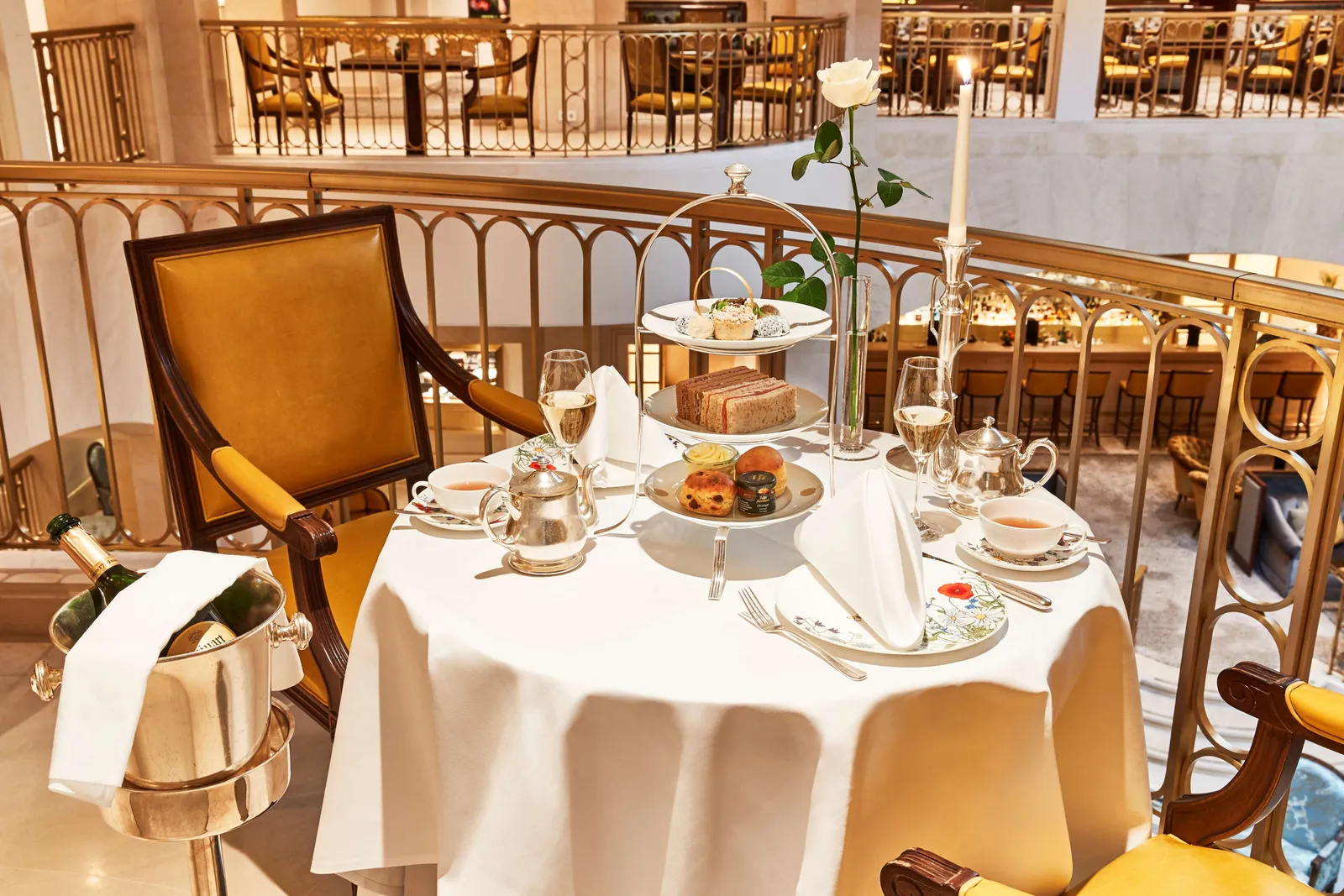 Tea on Bel Etage, with a tiered stand of cakes and sandwiches, teapots and champagne glasses.