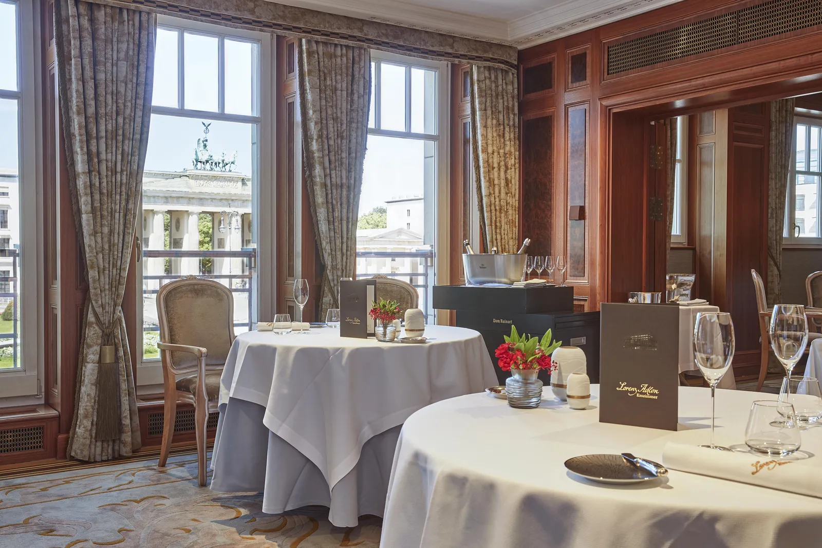 White-clothed tables, wood panelling and a view of the Brandenburg Gate at Lorenz Adlon Esszimmer.