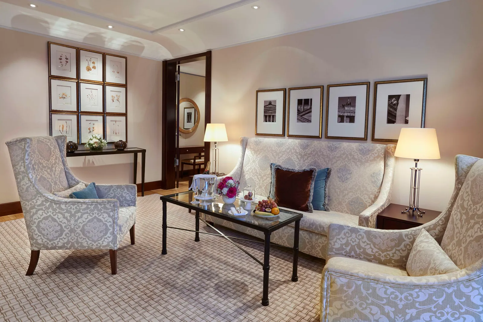 Berlin Suite with a pale sofa, blue-patterned armchairs and framed photographs.