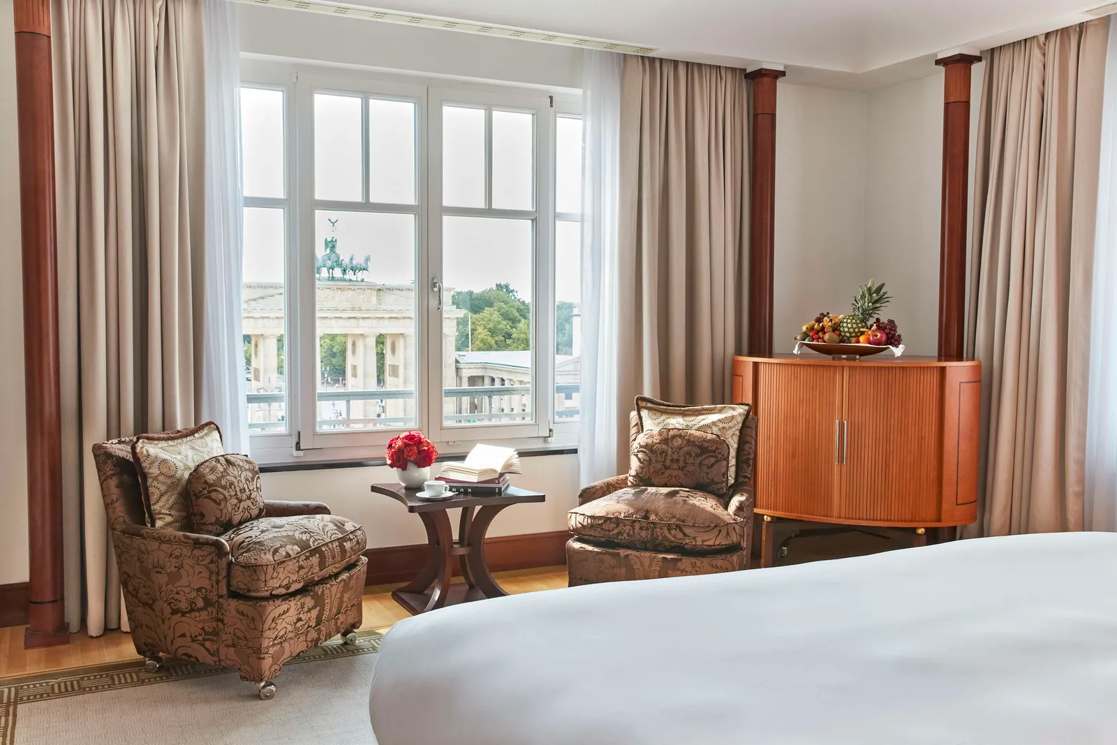 The Brandenburg Gate Suite sitting area, with 2 armchairs by the window and the Gate beyond.