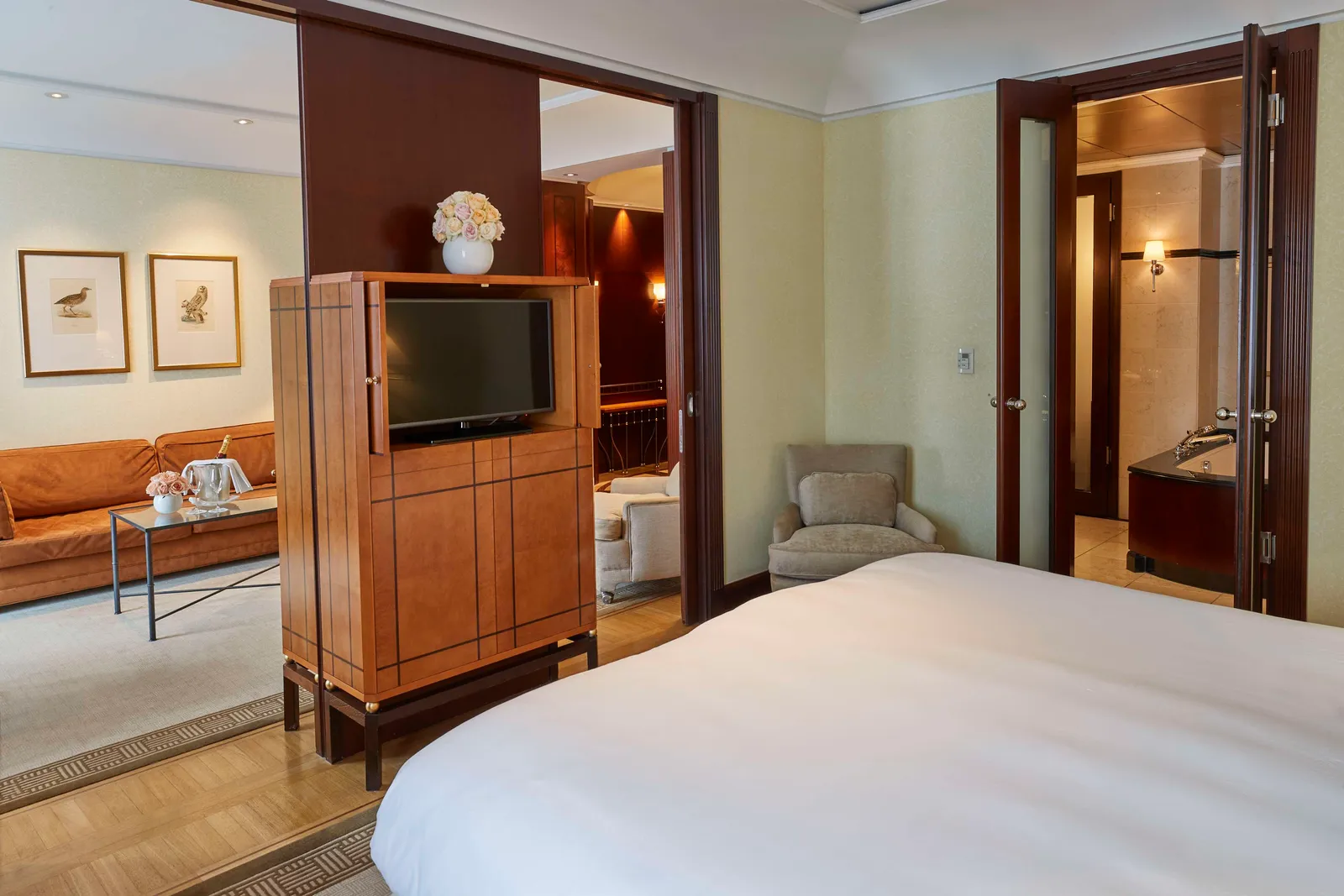 The Executive Suite bedroom, with its bed, television cabinet and opening towards the living room.