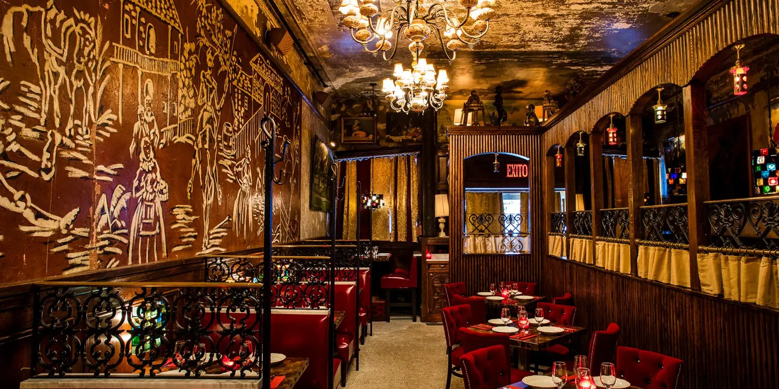 El Quijote’s dining room: the windmill mural in white brushstrokes, the chandeliers, the red booths