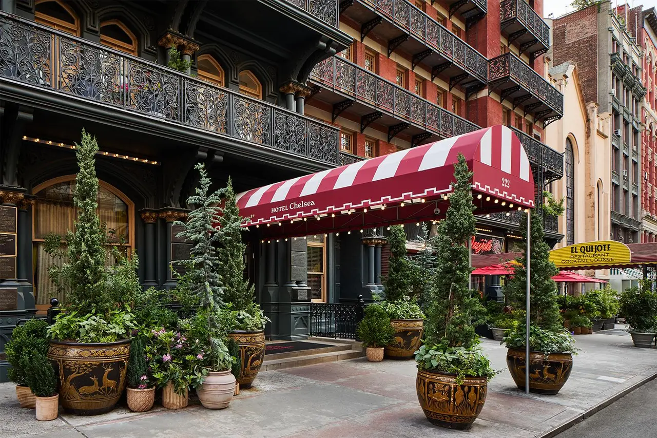 The entrance on 23rd Street with its red-and-white striped awning and potted topiary