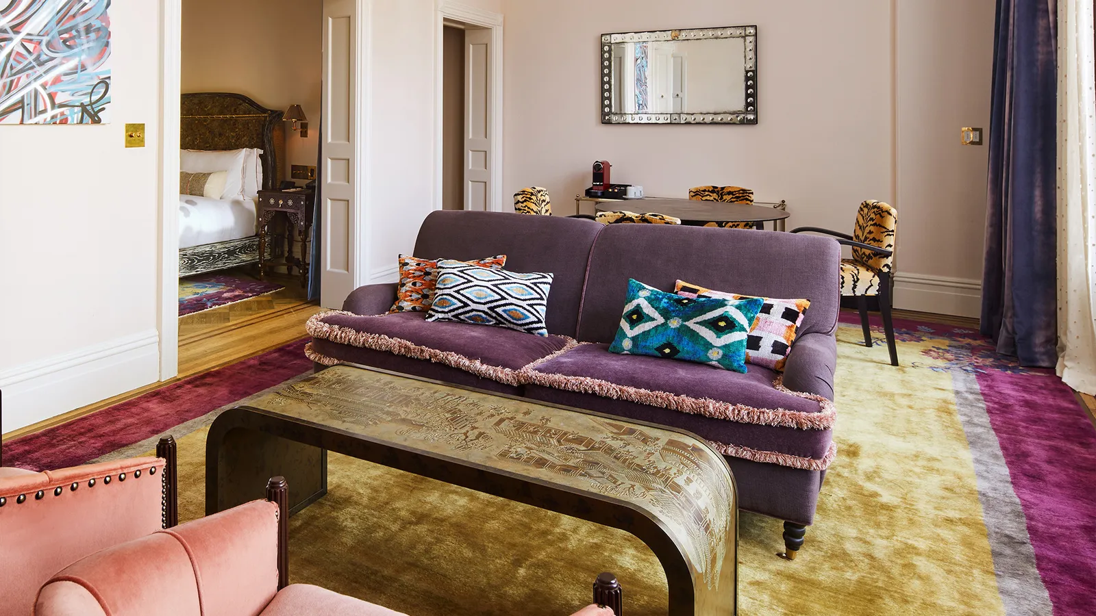 A Chelsea Grand Loft living room, the purple sofa and a gilded table on the rug
