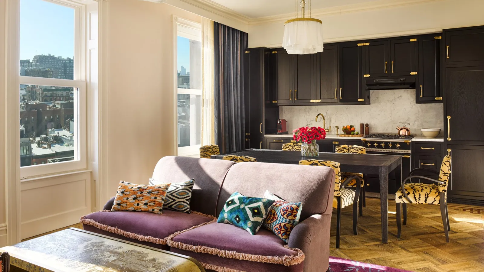 A Chelsea Grand Suite living room with the black kitchen behind