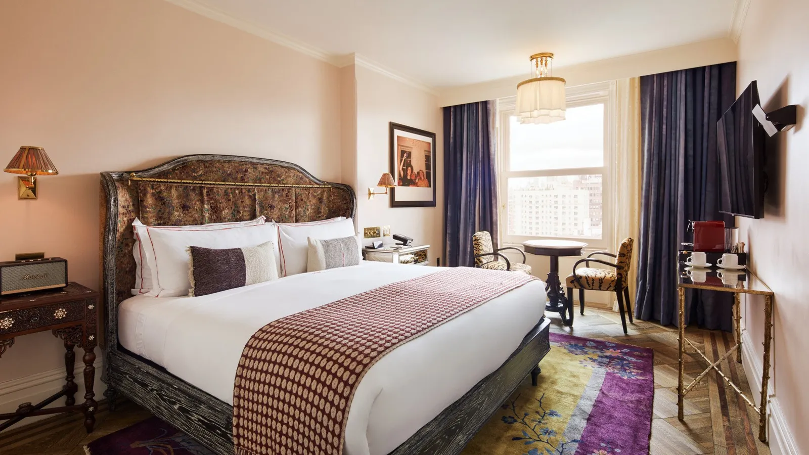 The Chelsea room with its king bed, check throw and a desk by the window