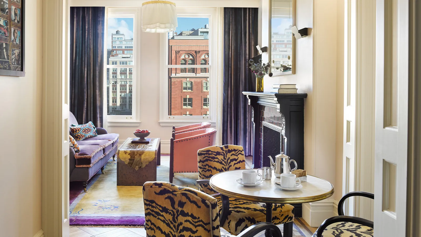 A Chelsea Suite seen from the bedroom: the dining table, tiger-print chairs and the sitting room by the window