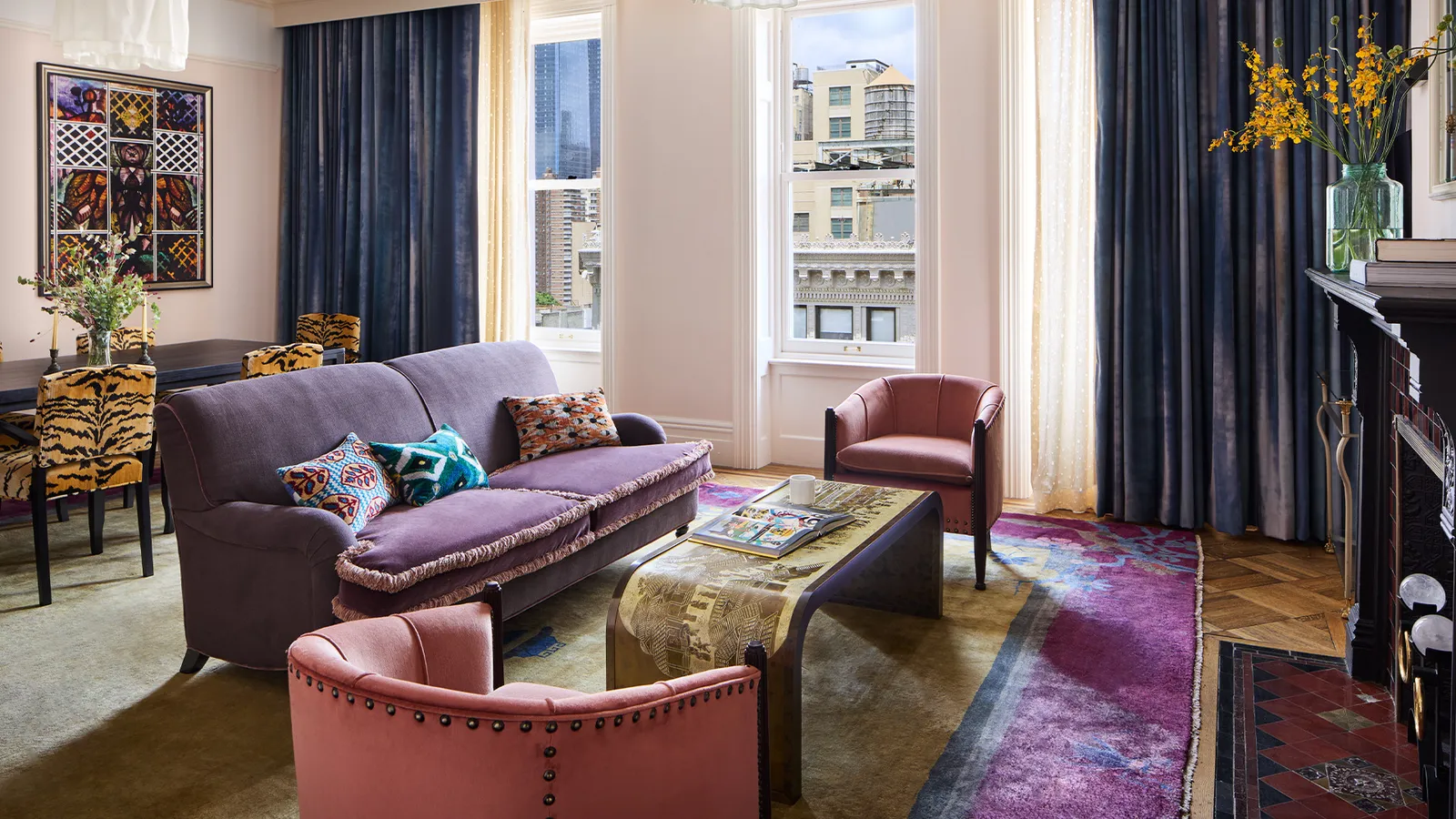 The Two Bedroom Suite sitting room, purple sofa and pink armchairs between the tall windows
