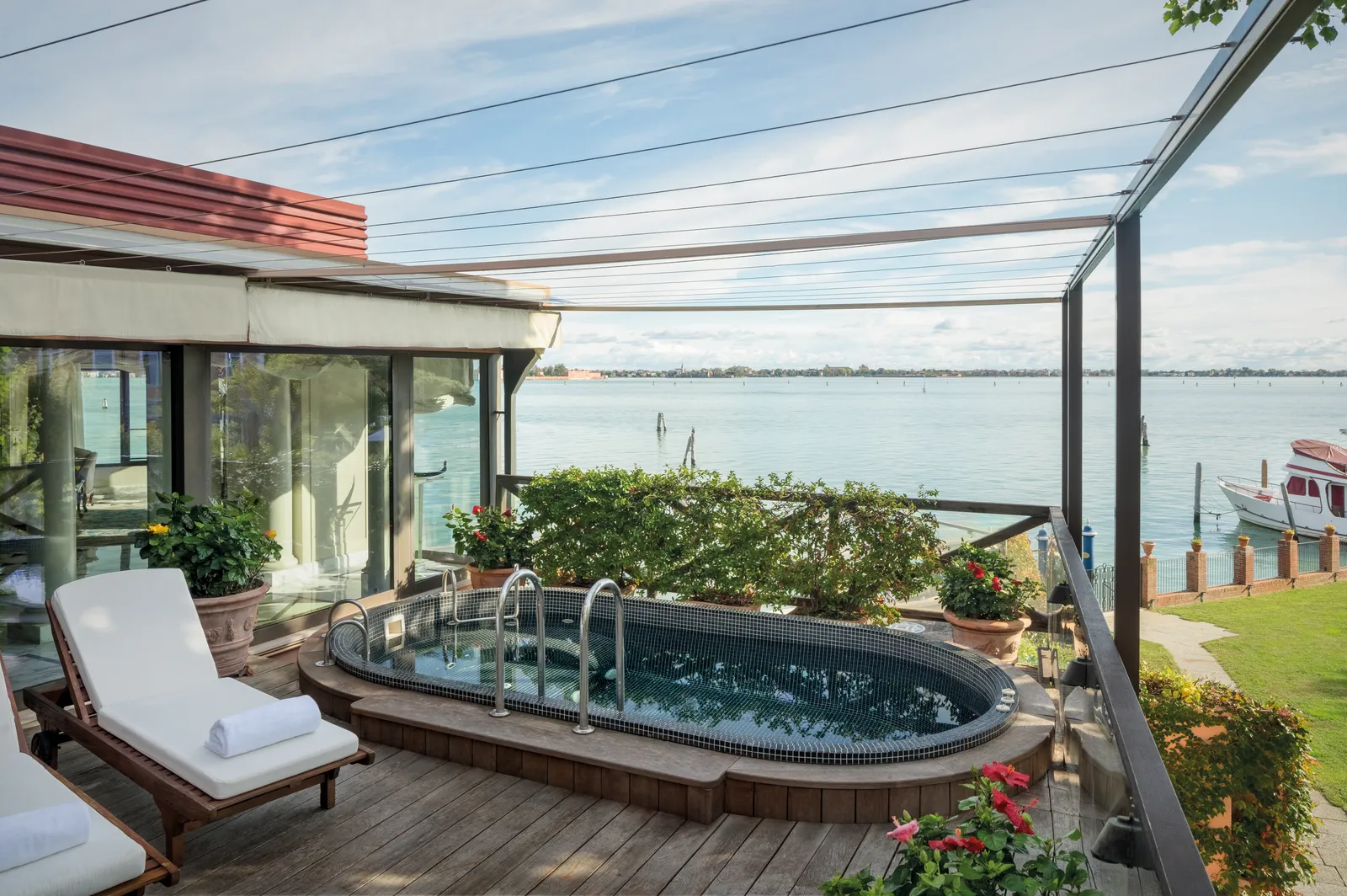 The Palladio Suite’s terrace, with its oval plunge pool set into the deck, a lounger and the open lagoon ahead.
