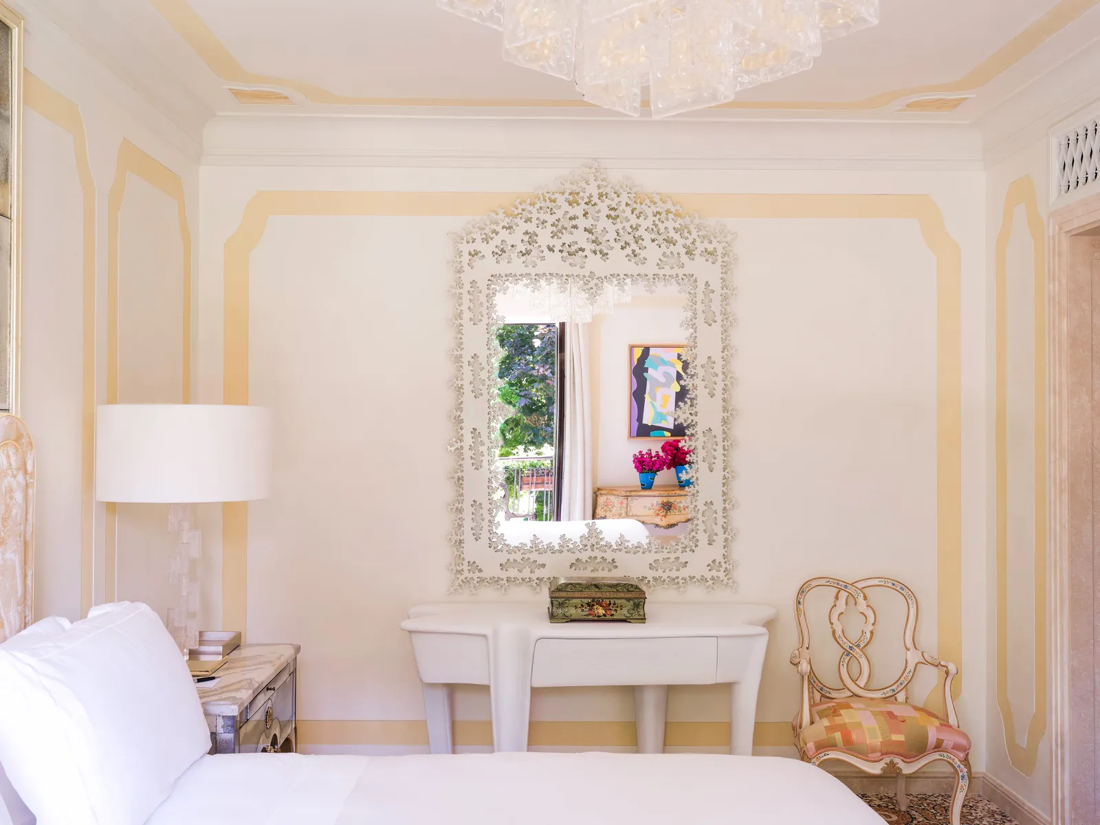 A Sophia Suite: a mirror in a white fretwork frame above the console, the bed and a Venetian chair.