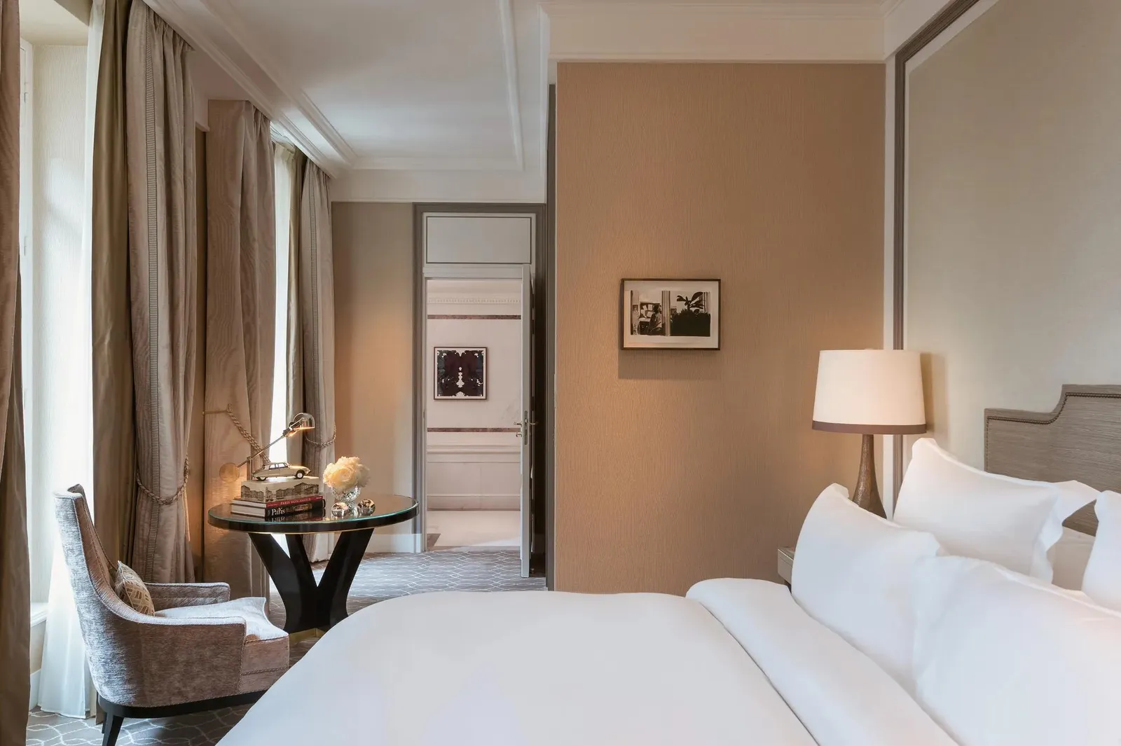 Bedroom with a white bed, window-side desk and beige walls