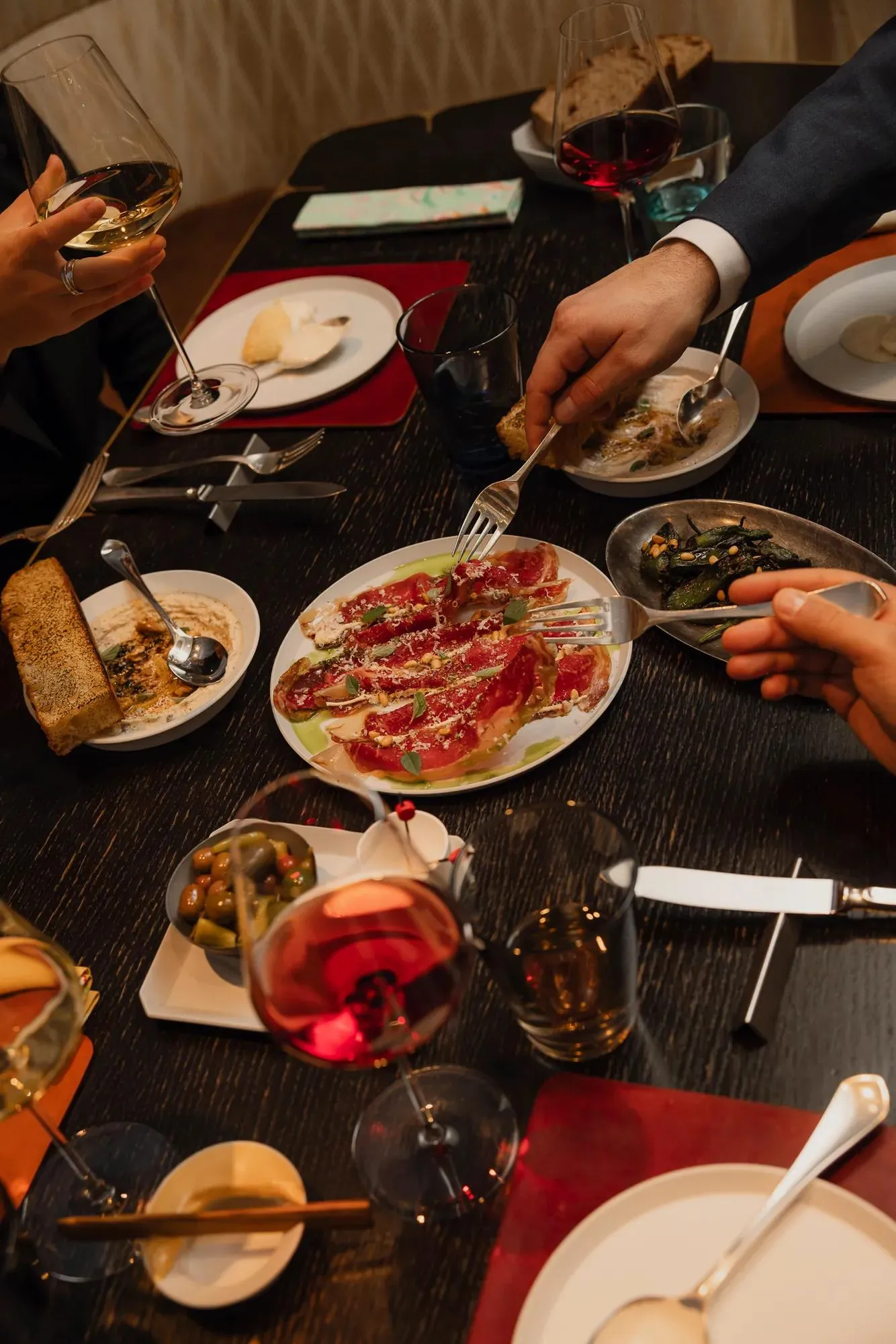 Dishes and diners’ hands at a Nonos table