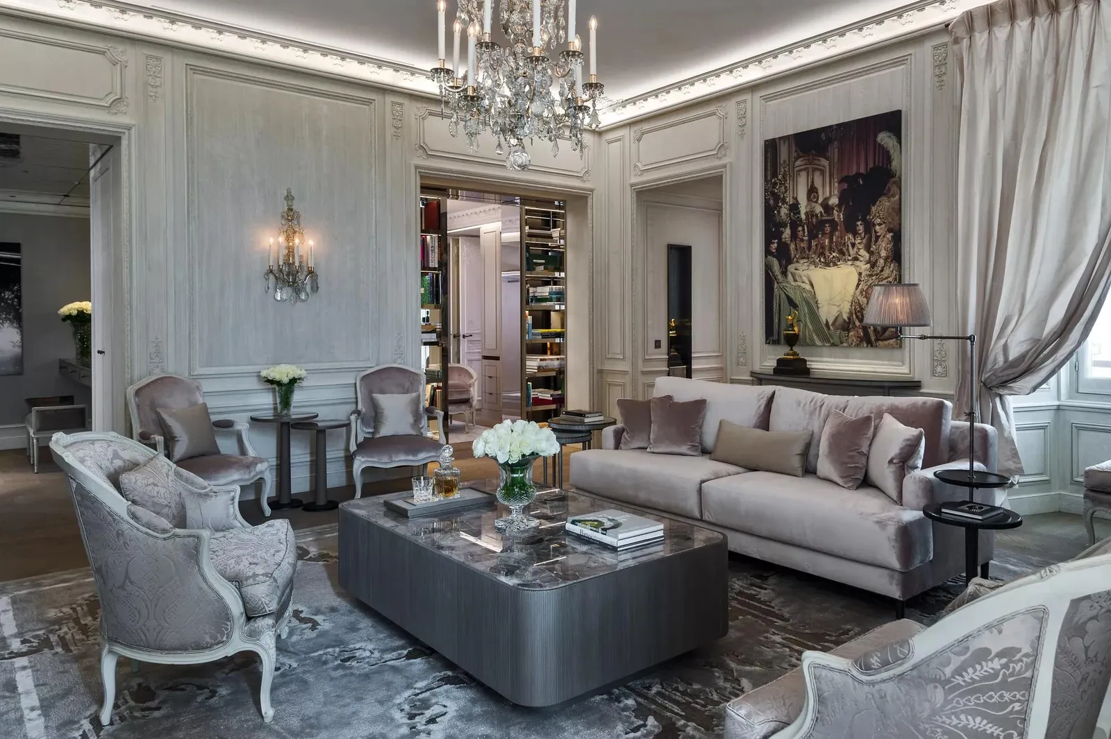 Sitting room with a grey sofa, mirrors and a chandelier