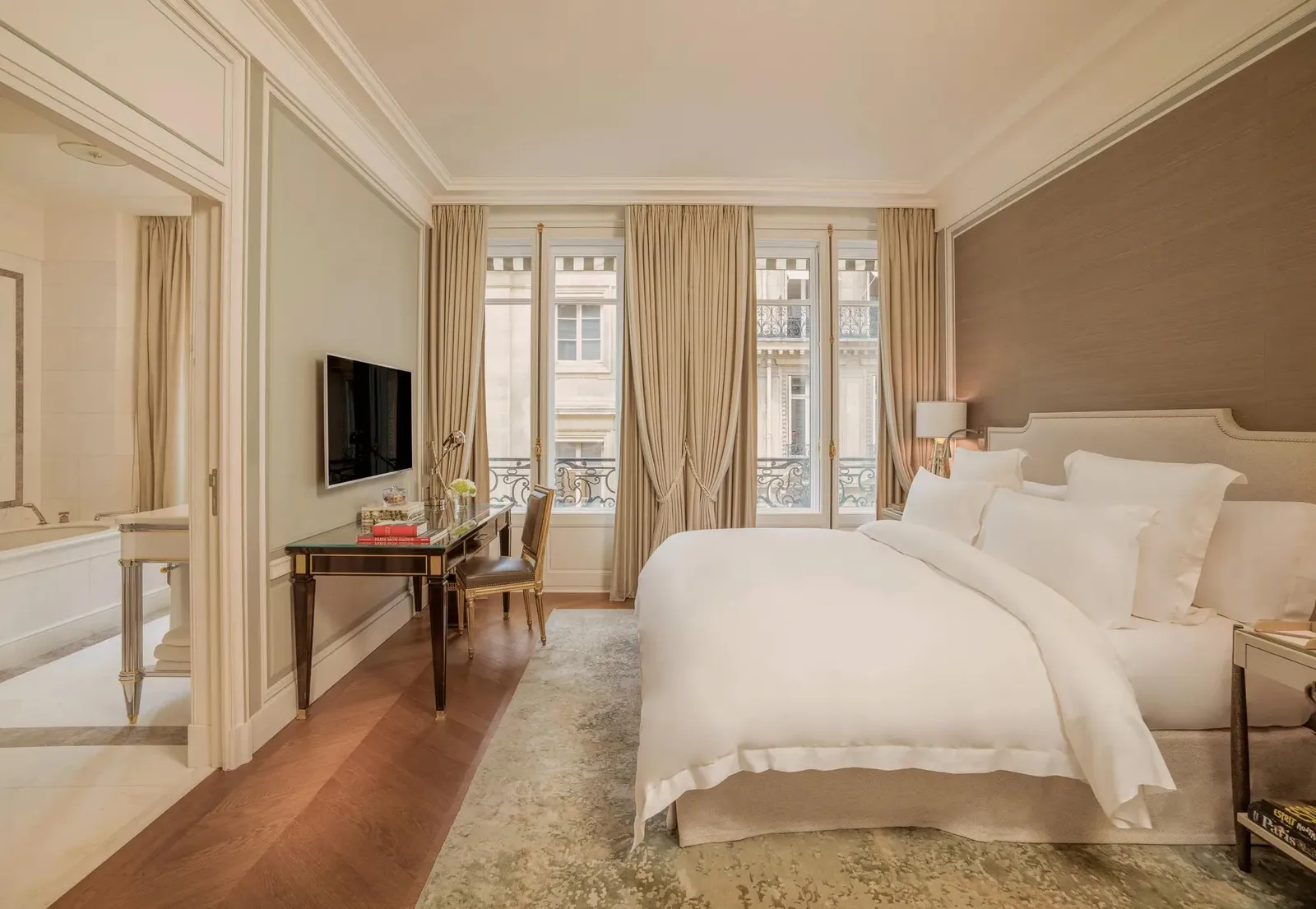 Bedroom with a white bed, mirrors and tall windows