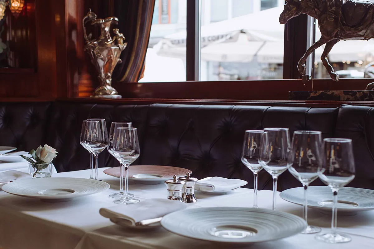 Tables at Restaurant de la Cigogne along the banquette