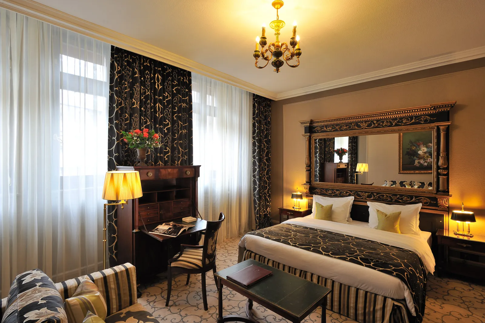 A Classic room with the bed below a carved mirror