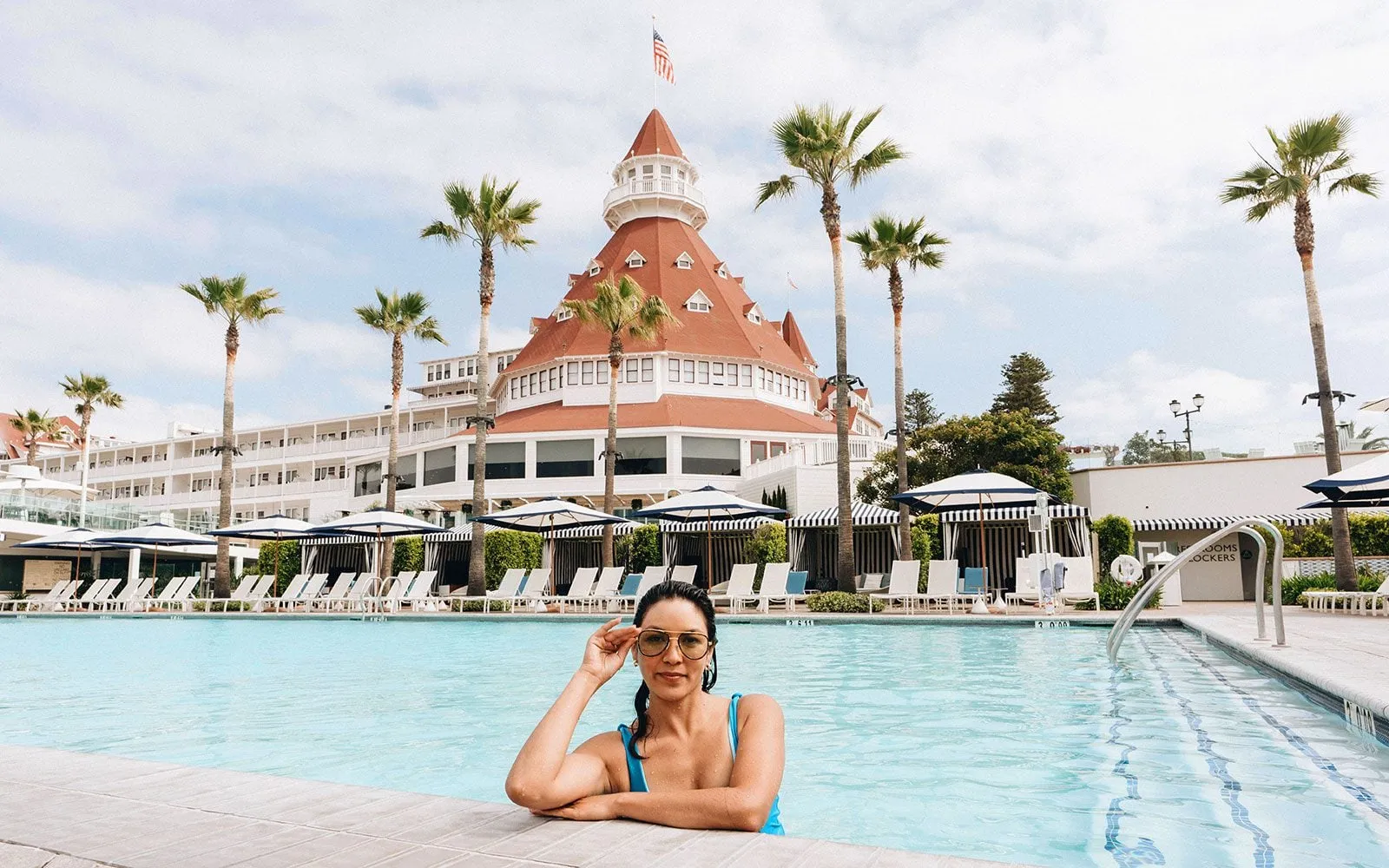 A woman in the Cabanas pool with the red turret beyond